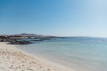 Calm beach with clear turquoise water and volcanic rocks