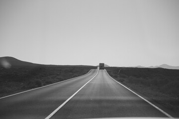 Camper van driving on an empty desert road in Fuerteventura