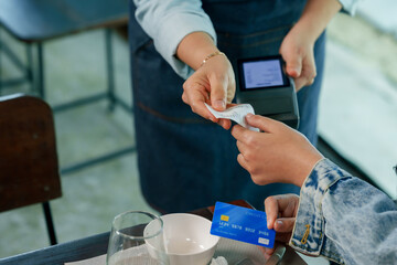 senior female restaurant owner handing printed receipt to customer after credit card transaction cashless payment contactless service inside cafe, modern technology small business lifestyle retail