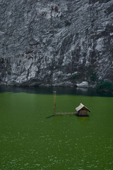 Solitary hut in the middle of green lake
