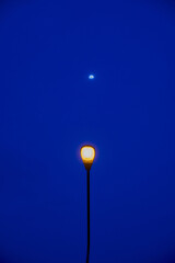 Streetlight glow under a midnight blue sky