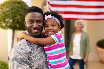 Portrait of happy african american daughter hugging army soldier on return against grandmother