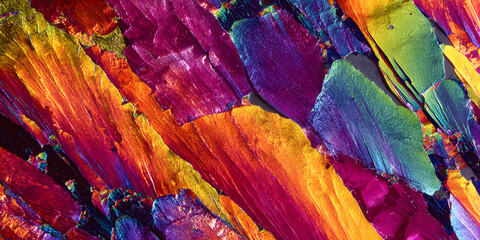 Liquid crystal patterns forming vibrant rainbow colors under microscope abstract science background