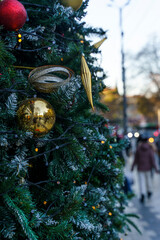 Festive Outdoor Christmas Tree Illuminated in a Bustling City Square 