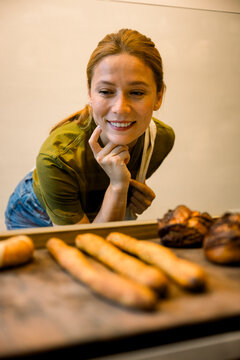 Happy client choosing bread and pastries at bakery counter