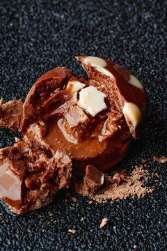 Smashed liquor-filled bonbon with soft interior and cream on black background