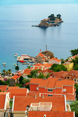 Fototapeta premium Scenic view of Petrovac town with red roofs and Sveta Nedelja island in Montenegro.