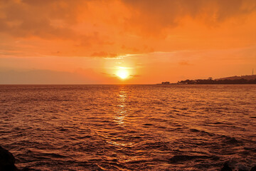 Obraz premium Vibrant sunset over the ocean with natural light creating a serene and peaceful atmosphere, ample copy space for inspirational quotes or travel promotions