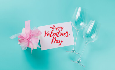 Gift box and wine glasses on blue background