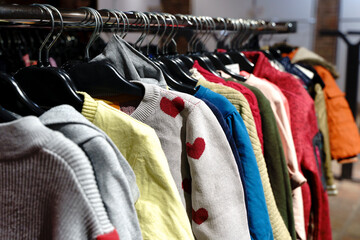 Assorted Vintage and Second Hand Clothing on Hangers in a Thrift Store