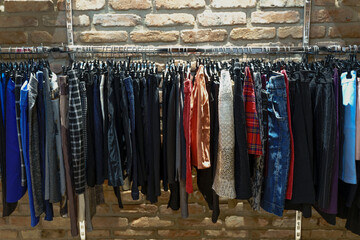 Assorted Vintage and Second Hand Clothing on Hangers in a Thrift Store