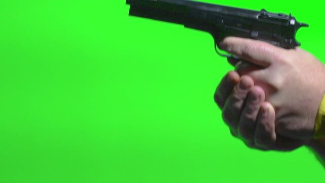 Close up of hand shooting a gun with both hands against a green screen background