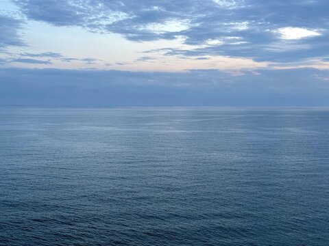 Calm sea and dark clouds in sky at evening.