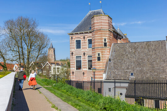 People walking the path along the historic Tolhuis building in Gorinchem, Netherlands