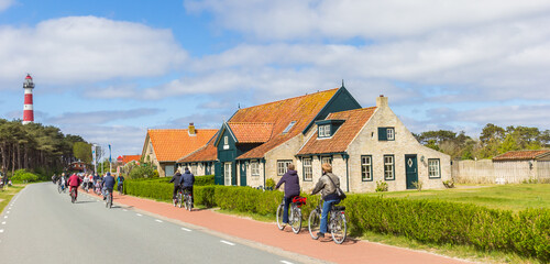 Tourists cycling to the historic lighthouse of Ameland, Netherlands