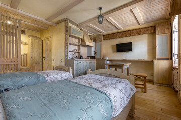 Cozy rustic studio interior with twin beds and wooden kitchen