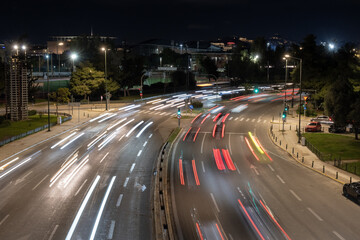 Night city traffic captured with long exposure showing dynamic light trails on a wide urban road in Athens, Greece. Modern transport, motion, speed and city life concept. © Olha