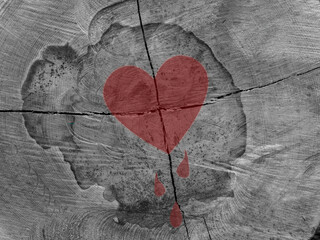Heartbreaker. Front side of a sawed-off tree trunk with large cracks. Red heart and red tears at the point where the cracks intersect.