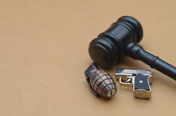Judge’s gavel beside handgun and grenade symbolizing justice, law enforcement, and legal consequences of weapons.