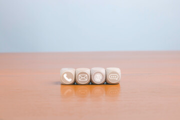 The contact and communication section uses wooden blocks to display icons for email, chat, and other symbols representing customer support, online messaging, and digital contact channels.