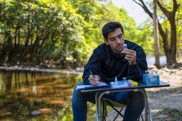 The environmentalist is testing a water Stream in the forest.