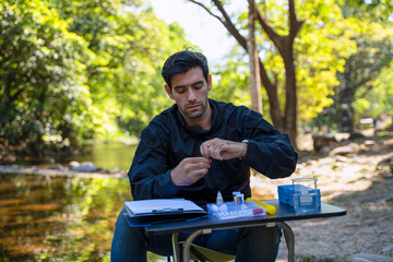 The environmentalist is testing a water Stream in the forest.