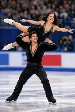 Pair figure skating overhead lift during competition performance. Concept of professional ice sports, athletic technique, teamwork, and high level performance under arena conditions