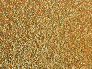 Gold grunge texture with uneven hammered metal look