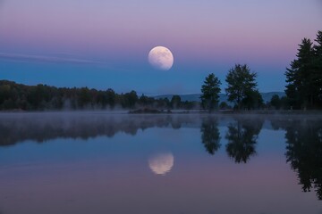 Fototapeta premium Serene lake scene with full moon rising over misty trees