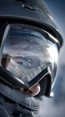 skier wearing snow goggles with mountain reflection