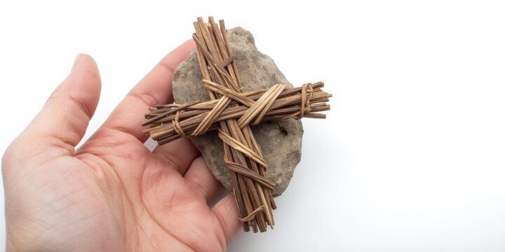 Hand holding bundled twigs on rock