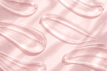 clear cosmetic gel strokes creating abstract patterns and textures on a soft pink background with natural light shadows depicting skincare wellness and beauty product applications