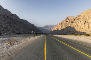 Naklejka premium Mountain road background with a stunning view of Jebel Jais under a cloudy sky, a beautiful travel destination in Ras Al Khaimah.