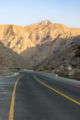 Mountain road background with a stunning view of Jebel Jais under a cloudy sky, a beautiful travel destination in Ras Al Khaimah.