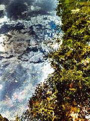 The last of the winter rain sits in puddles in the almost dry dusty river bed, the morning sky and grey is reflected in the water . High quality photo