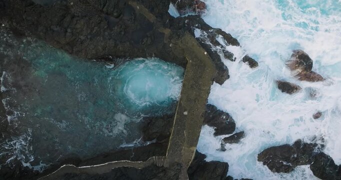 Natural ocean swimming pool with crashing waves in Garachico, Tenerife, aerial view