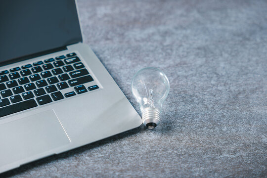 Growth strategy improves business development using light bulb idea beside laptop keyboard, marketing concept represents creative solution for energy and future growth success - Powered by Adobe