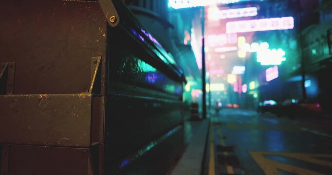 A bustling street illuminated by colorful neon signs comes alive at night. A dumpster stands prominently, adding to the urban backdrop filled with distant vehicles and shadows.