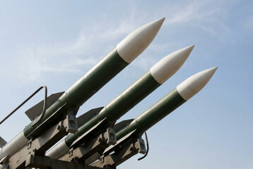 Three military missiles poised for launch against a clear blue sky