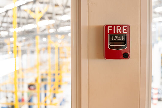 Fire alarm system notifier on wall background.Red wall-mounted fire alarm pull station in the office.Fire alarm systerm control and risk management concept.