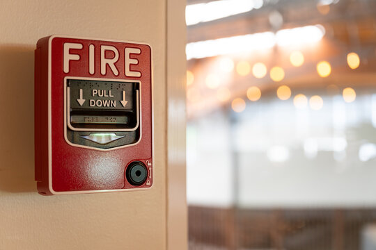 Fire alarm system notifier on wall background.Red wall-mounted fire alarm pull station in the office.Fire alarm systerm control and risk management concept.