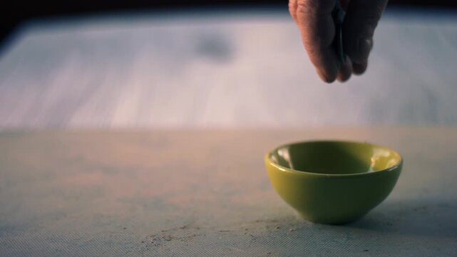 Hand dropping money into a tip jar bowl