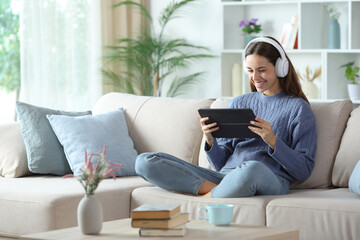 Happy woman using headphone and tablet to watch videos