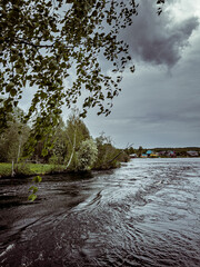 Sky during a thunderstorm, view of dark clouds moving in strong wind and heavy rain over the Mae River, Karelia region. High quality photo