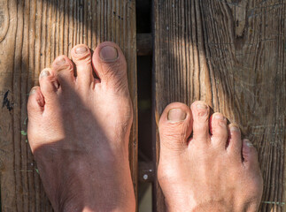 Feet of a man on a wooden background. Close-up.