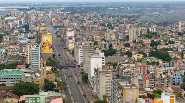 Aerial view of sun-kissed buildings and streets stretch towards the horizon, blending urban sprawl with the vibrant pulse of the city, Maputo, Cidade de Maputo, Mozambique.