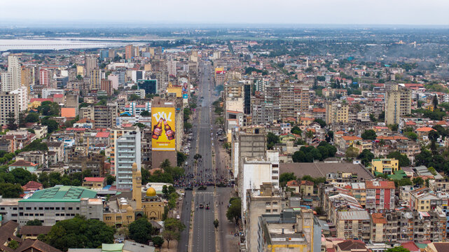 Aerial view of vibrant city streets cutting through dense urban sprawl, with a prominent billboard adding a splash of color to the skyline, Maputo, Cidade de Maputo, Mozambique.