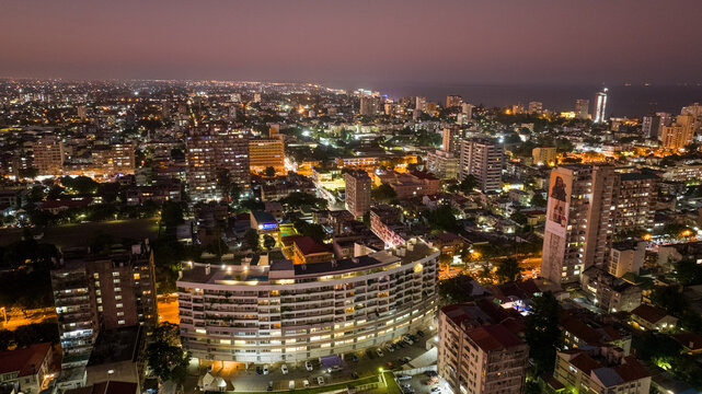 Aerial view of the illuminated cityscape with buildings and lights creating a vibrant tapestry against the twilight sky, Maputo, Cidade de Maputo, Mozambique.