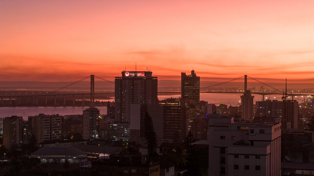 Aerial view of the skyline silhouetted against a fiery sunset, the bridge stretching across the water, Maputo, Cidade de Maputo, Mozambique.