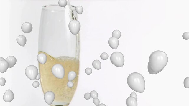 Off-screen pouring champagne into flute, filling glass, bubbles forming and droplets drifting
